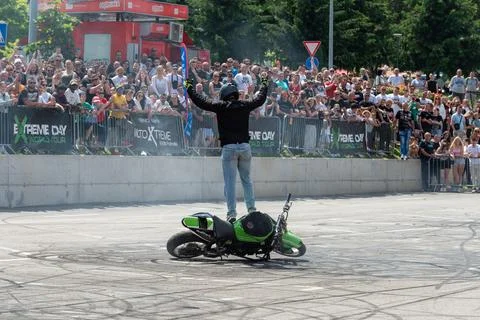Stunt driver greets audience standing on his motorbike Stock Photos