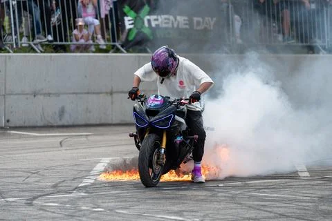 Stunt driver perform burnout in fire with his motorbike Stock Photos