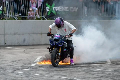 Stunt driver perform burnout in fire with his motorbike Stock Photos