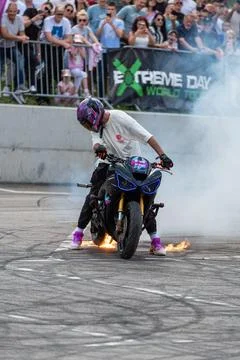 Stunt driver perform burnout in fire with his motorbike Stock Photos