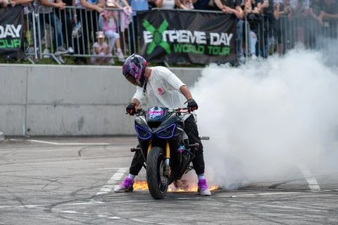 Stunt driver perform burnout in fire with his motorbike Stock Photos