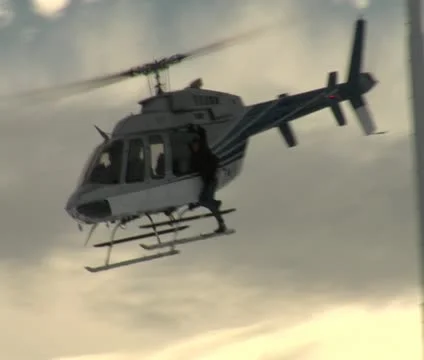 Stuntmen hangs onto side helicopter Stock Footage 21526577