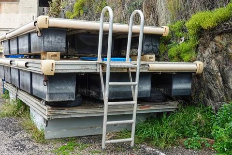 A sturdy floating platform is positioned beside a rocky coastline, featurin.. Stock Photos