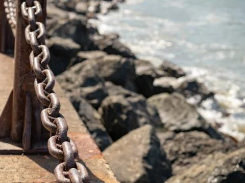 Sturdy, rusty chain blocking the sea with copy space to the righ Stock Photos