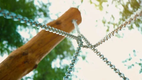Sturdy steel chains for the swing are attached to wooden supports, a bottom view Stock Footage 89921228
