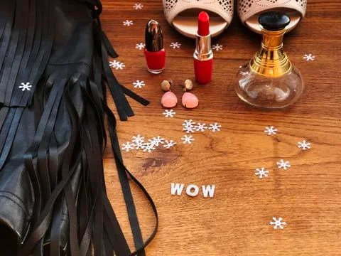 Style flat lay. Party style. Leather black dress with fringe, earings, red na Stock Photos