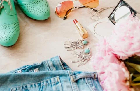 Styled flat lay background. Pink peony flower with jeans and shoes. Stock Photos
