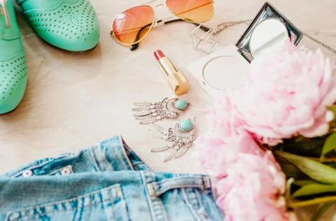 Styled flat lay background. Pink peony flower with jeans and shoes. Stock Photos