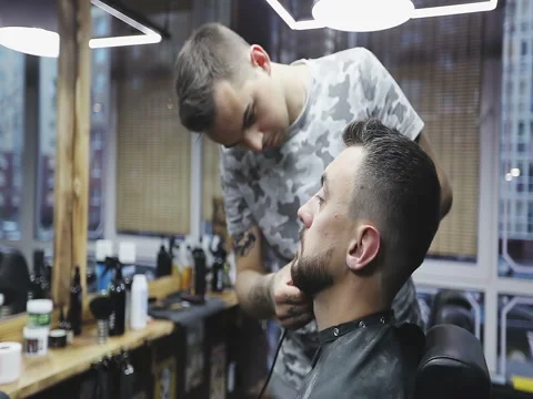 Styling with electric trimmer. Barber hand cutting beard with clipper at barbers Stock Footage 79713198