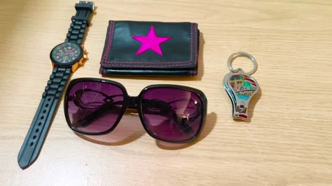 Stylish accessories collection featuring a black watch, a wallet with a pink Stockbeeldmateriaal 318610827