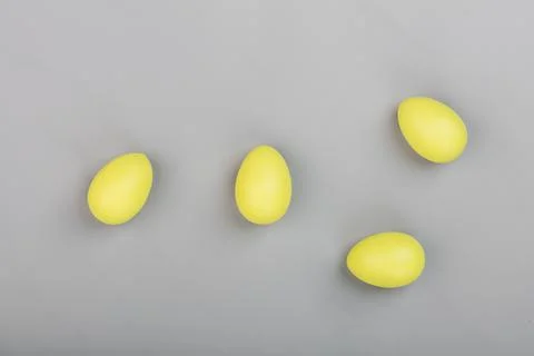 Stylish background with yellow easter eggs isolated on gray background. Flat lay Stock Photos