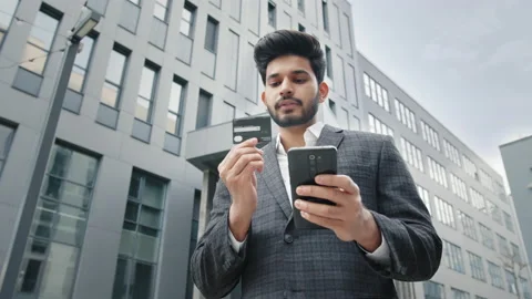 Stylish bearded man doing online purchases while standing near office building Stock Footage 156762860