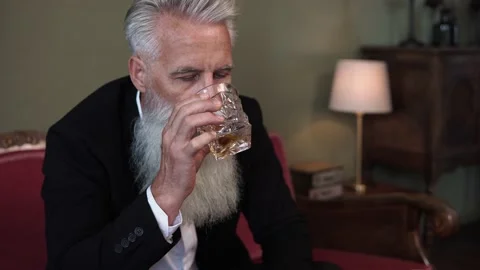 Stylish bearded senior man drinking whiskey Stock Footage 233654695