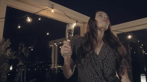 Stylish beautiful young long-haired woman with a glass of champagne dancing Stock Footage 116646494