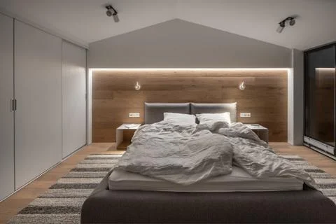 Stylish bedroom in modern style with light walls and luminous lamps Stock-Fotos