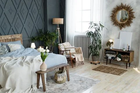 Stylish bedroom setup includes rustic wooden bed, dreamcatcher, and soft Stock Photos