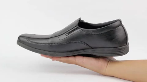 Stylish black leather shoe being presented on a hand Stock Footage 319507108
