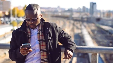 Stylish black man posing with phone at the train station Stock Footage 86468573