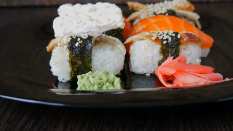 Stylish black sushi set on flat plate with different kinds of roll, nigiri, maki Stock Footage 87844659