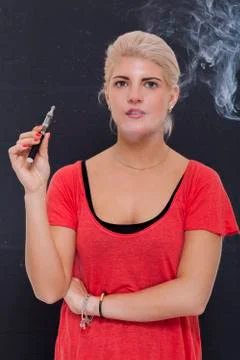Stylish blond woman smoking an e-cigarette Stock Photos