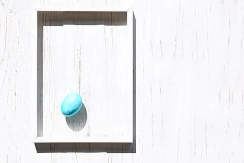 Stylish blue easter egg in white frame on white wooden background. Happy Ea.. Stock Photos