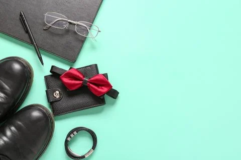 Stylish bow tie with wallet, notebook, eyeglasses and leather shoes on turquo Stock Photos