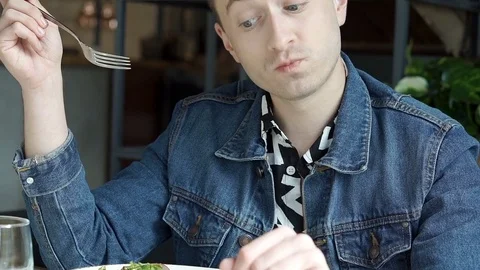 Stylish boy looks satisfied while eating delicious lunch in the restaurant, stea Stock-Footage 79377506