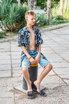Stylish boy sits on automatic lifting pole on city street 写真素材