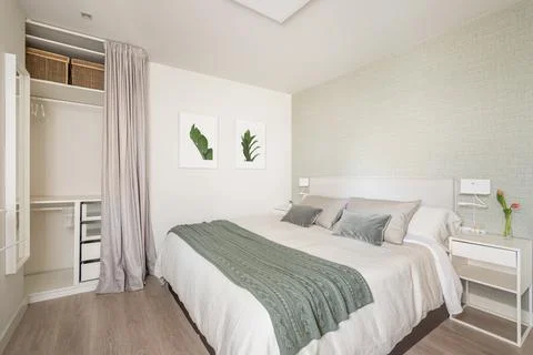 Stylish bright bedroom with a bedside table and a double bed and an empty Stock Photos