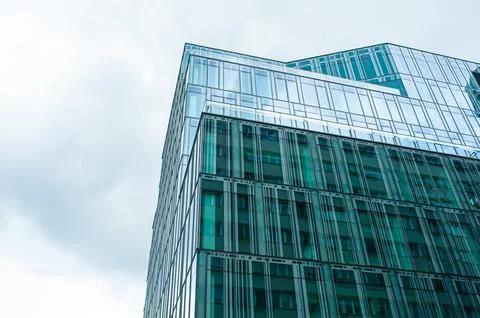 Stylish building with many windows under cloudy sky, low angle view Fotos de archivo