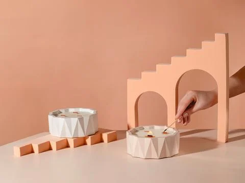 A stylish candle setup on a light-colored table. Two geometric candles are Stock Photos