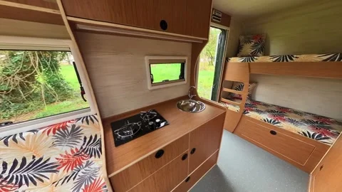 A stylish caravan video with a kitchen, seating area, and beds. Video stock 242455311