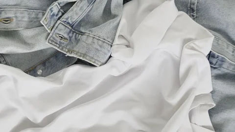 Stylish casual clothes top view close up. Fashion t-shirt mockup with label, jea Stock Footage 340842354