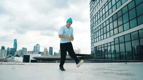 Stylish caucasian dancing man performing break dance at skyscraper. Hiphop. Stock Photos