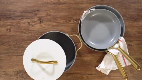 Stylish Ceramic Cookware with Gold Handles on Wood Vídeos de archivo 313799076
