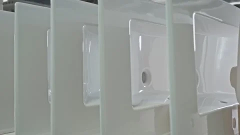 Stylish ceramic sinks are stacked on a rack in a sanitary ware production Stock Footage 256068645