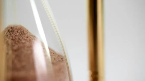 Stylish close up of sand falling throuhg an hour glass Stock Footage 252519691