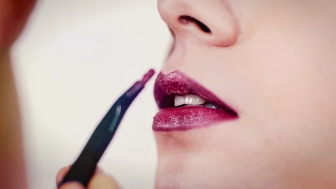 Stylish Close Shot of Makeup Applying Brush Lipstick on Girl's Lips Stock Footage 129386057