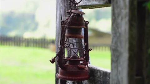 Stylish close up shot of an old rusty paraffin lamp hanging on a wooden gate Stock Footage 307398663