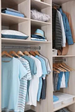 Stylish clothes and home stuff in large wardrobe closet Stock Photos