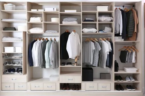 Stylish clothes, shoes and home stuff in large wardrobe closet Stock Photos