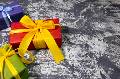 Stylish colored gift boxes with ribbons on grey background. Space for text. 스톡 사진