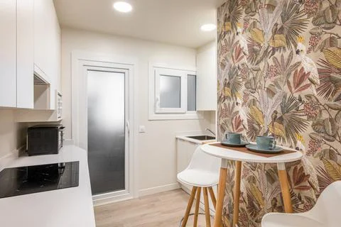 Stylish comfortable compact kitchen with a small table and a comfortable cooking Stock Photos