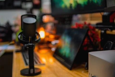 Stylish computer desk setup with dual monitors, a microphone. Foto stock