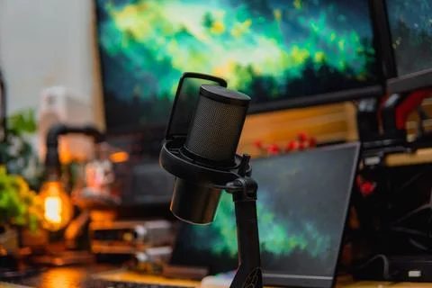 Stylish computer desk setup with dual monitors, a microphone. Stock Photos