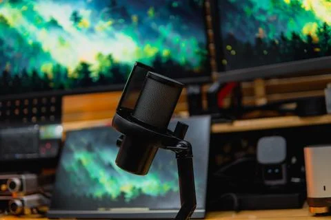 Stylish computer desk setup with dual monitors, a microphone. Foto stock