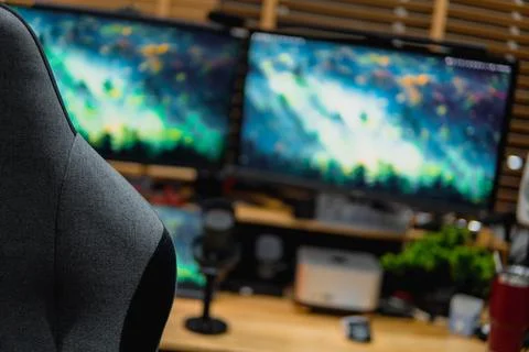 Stylish computer desk setup with dual monitors, a microphone. Foto stock