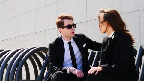 A Stylish Couple Engaged in a Lively Conversation Under the Warm Embrace of Stock Footage 312036023