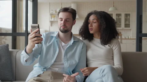 Stylish Couple Talking On Smartphone Video Call While Sitting On Sofa 스톡 동영상 331789032