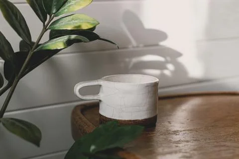 Stylish cup in sunlight on rustic background. Morning coffee aesthetics Stock Photos